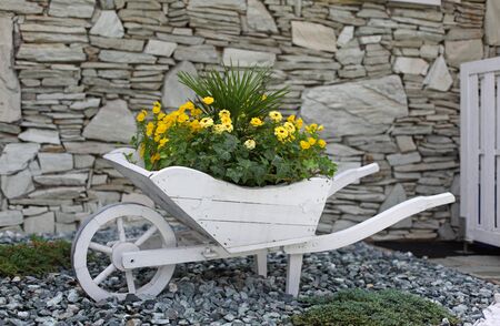 Flower bed pushcart in front of a houseの写真素材