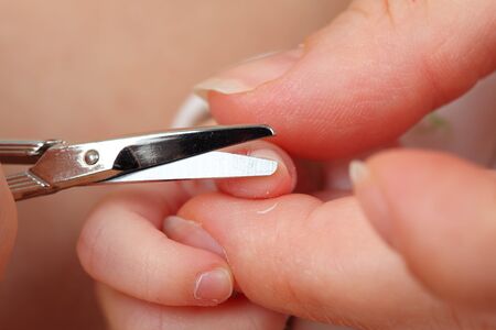 Mother cutting little baby's fingernailsの写真素材