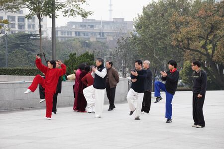 Chinese people practicing Tai Chi Chuan in the morning at The Bund, Shanghai China. Photo taken at 17th of November 2010のeditorial素材