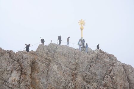Hikers at the cross on the summit of Zugspitze Mountain, Alps Germany. Photo taken at 5th of July 2009のeditorial素材