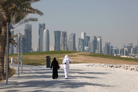 Arabic couple walking in front of Doha skyline, Qatar. Photo taken at 8th of January 2012のeditorial素材