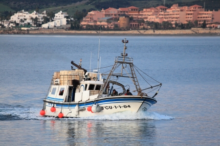 Fishing boat returning to home harbor with lots of seagulls. Estepona, Andalusia, Spainのeditorial素材