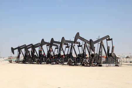 Black oil pump jacks in the desert of Bahrainの写真素材