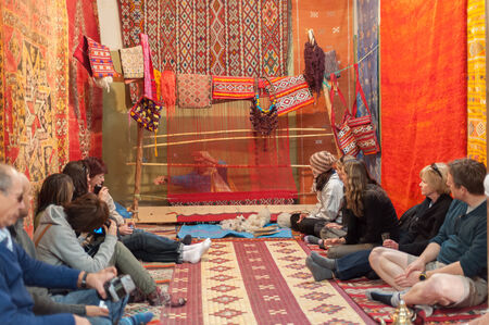 Tourists watching moroccan woman weaving traditional carpet. Morocco, Africaのeditorial素材