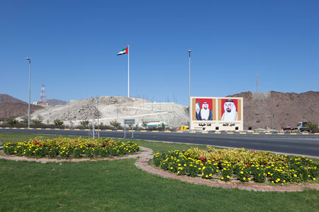 FUJAIRAH, UAE - DEC 14: Roundabout in Fujairah with national flag and portraits of the rulers. December 14, 2014 in Fujairah, UAEのeditorial素材