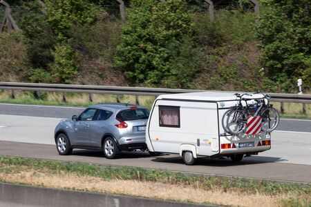FRANKFURT, GERMANY - JULY 21: Nissan Juke with with a small caravan travelling at the A5 highway in...