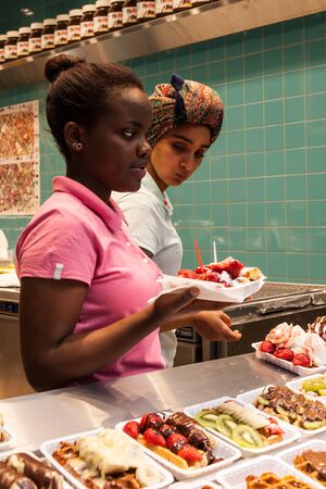 BRUSSELS, BELGIUM - AUG 22: Female shop assistants selling traditional waffles to tourists in Brussels. August 22, 2015 in Brussels, Belgiumのeditorial素材