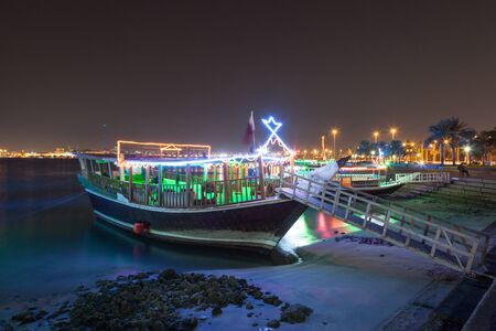 Cruise dhow at the corniche of Doha at night. Qatar, Middle Eastの写真素材