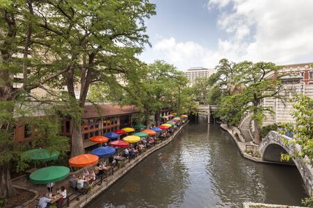 SAN ANTONIO, USA - APR 11: The famous San Antonio River Walk and a cafe with colorful umbrellas. April 11, 2016 in San Antonio, Texas, United Statesのeditorial素材