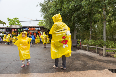 GUNZBURG, GERMANY - AUG 18, 2016: Family wearing yellow ponchos at the Legoland Deutschland in Guenzburg, Baden Wurtemberg, Germanyのeditorial素材