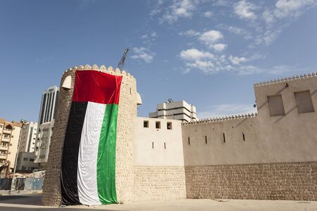 Historic fort decorated with UAE national flag in the city of Sharjah, United Arab Emiratesの写真素材