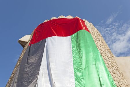 Old tower decorated with the UAE national flag. Dubai, United Arab Emirates, Middle Eastの写真素材