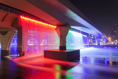 Dubai Water Canal Waterfall illuminated at night. United Arab Emirates, Middle Eastの写真素材