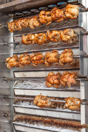 Whole roasted chickens on a skewerの写真素材