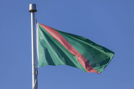 The Ismaili Flag waving in the wind against a blue sky の写真素材