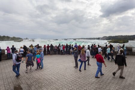 Niagara Falls, Canada - Oct 15, 2017: Tourists at the viewing platform at the Niagara Falls. Province of Ontario, Canadaのeditorial素材