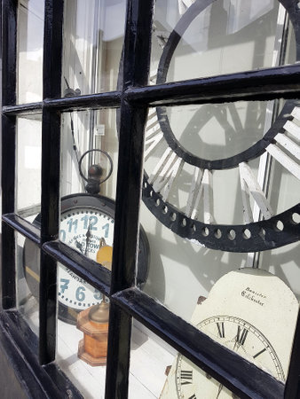Old clocks in the window of a shop in Essex, England.