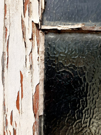 Detail of an old wooden door with cracked paint and patterned glass.の写真素材