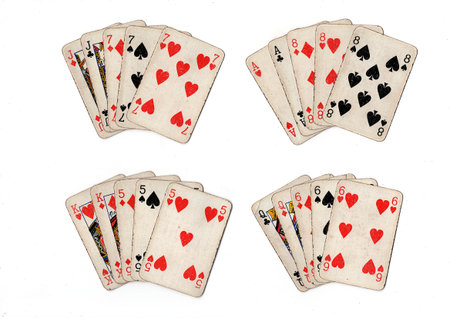 poker hands of old grubby playing cards in different combinations on a white background.