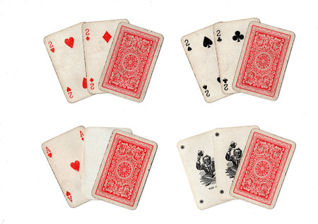 Hands of three old grubby playing cards in different combinations on a white background.の写真素材