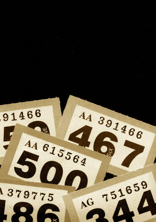 Vintage raffle tickets in sepia on a black background.