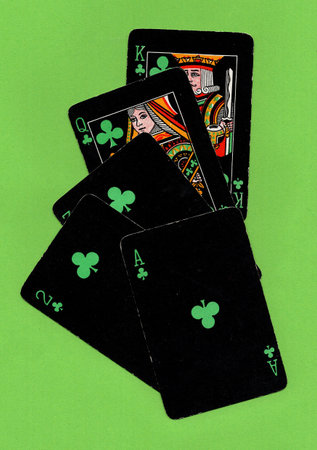 Black vintage playing cards on a bright green background.
