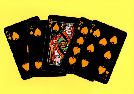 Black vintage playing cards on a bright yellow background.の写真素材