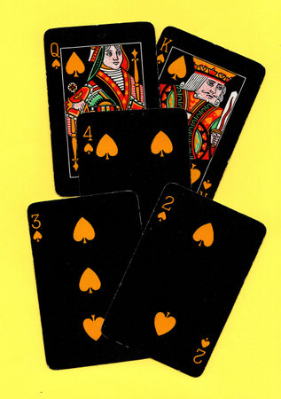 Black vintage playing cards on a bright yellow background.