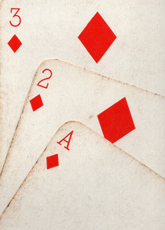 Close up detail showing a run of three vintage playing cards in the same suit.の写真素材