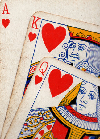 Close up detail showing a run of three vintage playing cards in the same suit.の写真素材