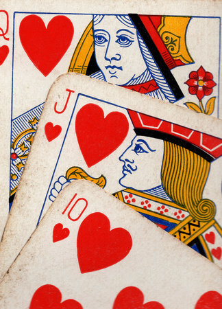 Close up detail showing a run of three vintage playing cards in the same suit.の写真素材
