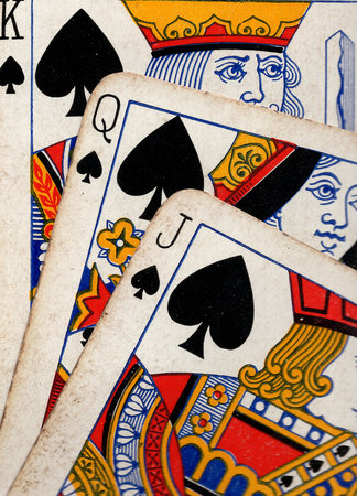 Close up detail showing a run of three vintage playing cards in the same suit.の写真素材