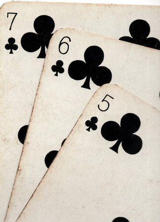 Close up detail showing a run of three vintage playing cards in the same suit.の写真素材