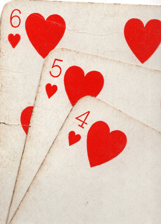Close up detail showing a run of three vintage playing cards in the same suit.の写真素材