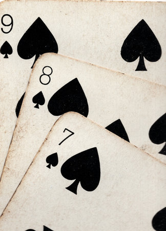 Close up detail showing a run of three vintage playing cards in the same suit.の写真素材