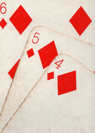 Close up detail showing a run of three vintage playing cards in the same suit.の写真素材