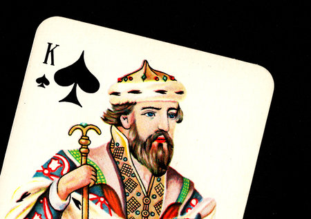Close up detail of a vintage playing card isolated on a black background.