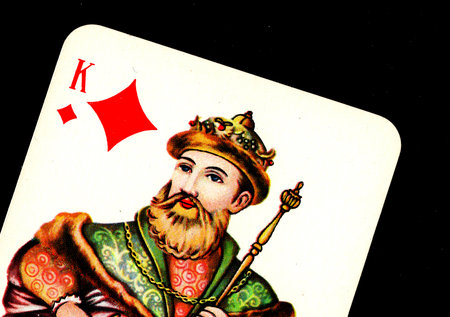 Close up detail of a vintage playing card isolated on a black background.
