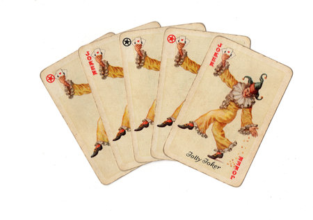 A hand of vintage joker playing cards isolated on a white background.