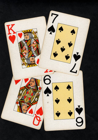 A hand of vintage playing cards isolated on a black background.
