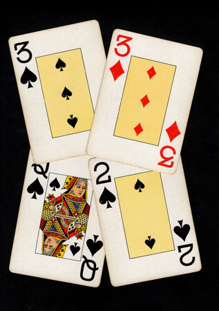 A hand of vintage playing cards isolated on a black background.