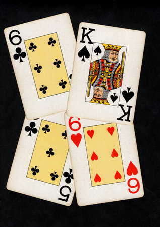 A hand of vintage playing cards isolated on a black background.