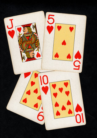 A hand of vintage playing cards isolated on a black background.