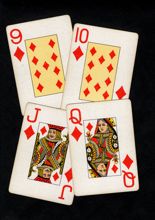 A hand of vintage playing cards isolated on a black background.