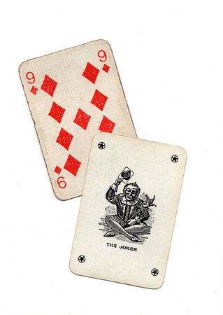 A pair of vintage playing cards showing a joker and one other card isolated on a white background.