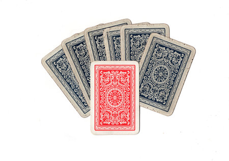 A hand of blue vintage playing cards with one red card.