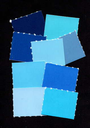 Blue torn paper colour swatches isolated on a black background.