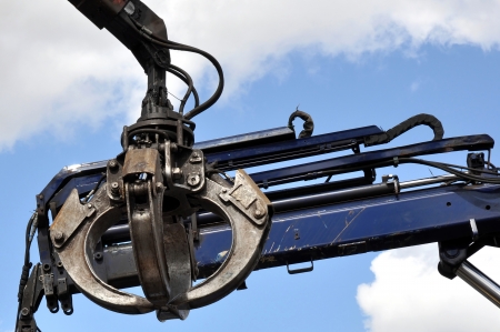 Scrap yard hydraulic Claw Crane with a sky background