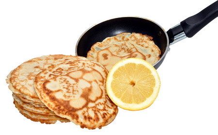 Freshly made pancakes with lemon and frying pan, traditionally eaten in England on Shrove Tuesday also known as pancake day, isolated on a white background の写真素材