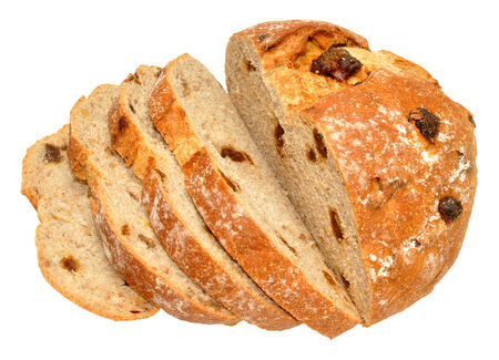 Partially sliced freshly baked walnut and date cob bread loaf isolated on a white background